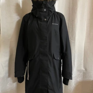Svart parkajacka från Didriksons - Snygg och varm vinterjacka från Didriksons. Modellen heter Erika. Nypris 3000kr, säljer för 1500kr. 