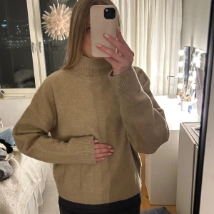 Beige stickad polotröja - Mysig beige stickad polotröja med långa ärmar och ribbade muddar. Perfekt nu till vintern.