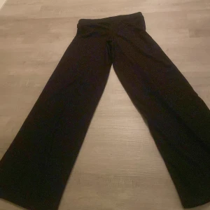 Svarta byxor från Gina Tricot - Snygga svarta byxor från Gina Tricot i storlek S. Byxorna har en loose passform med en hög midja och vida ben, vilket ger en trendig look. Perfekta för en stilren outfit.