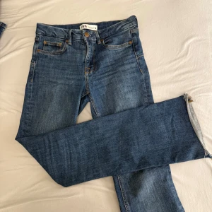 Blå jeans från Zara - Säljer ett par klassiska blå jeans från Zara i storlek S. De har en snygg flare passform vid benen och är tillverkade i denim. Medelhög midja 