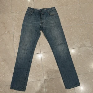 Blå jeans från Jacob Cohen - Snygga blå jeans från Jacob Cohen med klassisk femficksdesign och knappgylf. Jeansen har en diskret tvättad look och är tillverkade i högkvalitativt material för en bekväm passform. Storlek W34 men sitter som W30 eftersom Cohën har sin egen storlek. Pris ej hugget i sten 🪨! Hör gärna av vid eventuella frågor!! ‼️🔥✅