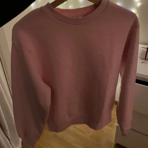 Rosa sweatshirt från Gina Tricot - Säljer en mysig rosa sweatshirt från Gina Tricot. Tröjan har en klassisk rund hals och långa ärmar, perfekt för en avslappnad stil. Passar bra till både jeans och leggings.