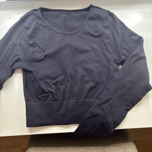 Svart ribbad tröja från Bikbok - Säljer en stilren svart ribbad tröja från Bikbok. Tröjan har en rund halsringning och långa ärmar, perfekt för en minimalistisk look.