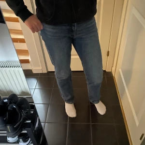 Blå jeans från Levi's - Säljer ett par klassiska blå jeans från Levi's med en straight passform. De är midwaist och har en snygg vintage-look. Perfekta för en avslappnad stil.