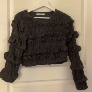 Svart volangtröja från NA-KD -  svart tröja från NA-KD med volangdetaljer, perfekt fest tröja!!