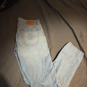 Levi's 502 ljusblå jeans - Säljer ett par klassiska Levi's 502 jeans i ljusblå denim. De har en straight passform och är perfekta för en avslappnad stil. Jeansens ikoniska lädermärke sitter på baksidan av midjan. L: 109, B: 47