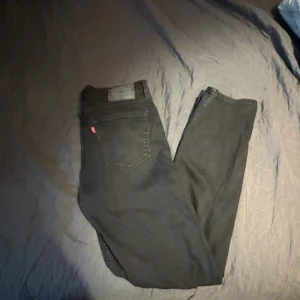 Svarta jeansbyxor från Levi's - Säljer ett par klassiska svarta jeans från Levi's. De har en rak passform och är tillverkade i slitstarkt denim. Perfekta för en stilren look. L: 109, B: 49