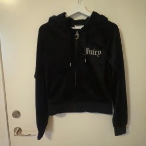 Svart velourset från Juicy Couture - Säljer ett svart velourset från Juicy Couture med glittrande Juicy-logga på både jacka och byxor. Jackan har dragkedja och huva, medan byxorna har en bekväm passform. Helt nya med prislapp kvar…säljer pga av strul vid retur.