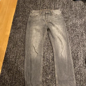 Grå jeans från Weekday - Snygga grå jeans från Weekday i en klassisk straight fit. Perfekta för en avslappnad stil med en modern touch. De har en traditionell femficksdesign och är tillverkade i slitstarkt denim.