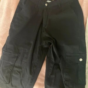 Kargobyxor - Svarta kargobyxor från Madlady. De är medel waisted & sitter åt vid anklarna. De har två fickor fram & två fickor på sidorna🖤Köptes för 500kr, men säljer för 250kr. Aldrig använda🖤