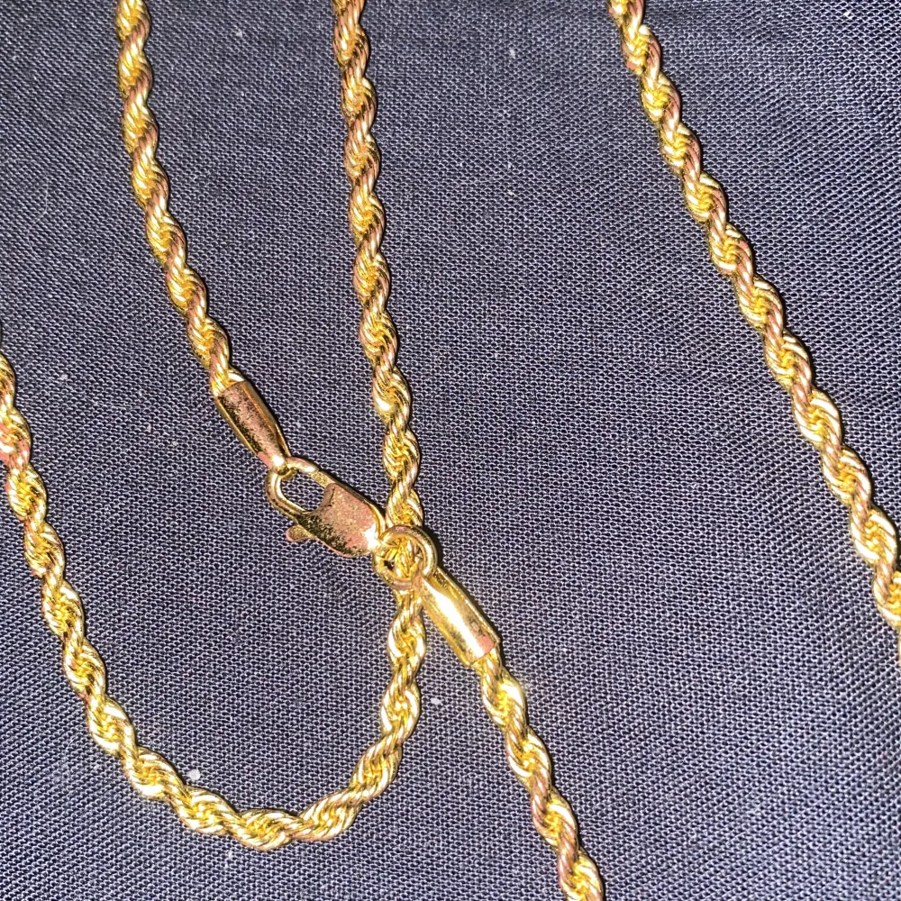 Elegant guldfärgat halsband med en tvinnad kedja. Perfekt för att lägga till en touch av stil till din outfit. Kedjan har en säker låsning som håller den på plats.. Asusteet.