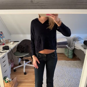 Svart croppad hoodie - Säljer en svart croppad hoodie med långa ärmar och en bekväm passform. Perfekt för en avslappnad stil. Den har en enkel design utan mönster.