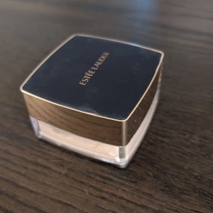 Estee Lauder Double Wear Sheer Flattery Loose Powder - Translucent matte löspuder från Estee Lauder i en elegant fyrkantig förpackning med mörkblått lock och guldiga detaljer. Inkluderar en mjuk appliceringspuff med band för enkel användning. Har använts några gånger, se bilder. Puffen är tvättad men fortfarande lite sminkspår kvar. Mer än hälften av produkten kvar i förpackningen. Nypris 565 :-
