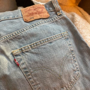 Levis 501 jeans i ljusblå denim - Klassiska Levis 501 jeans i ljusblå denim. De har en knappgylf och den ikoniska Levis-lappen baktill. Perfekta för en avslappnad stil.