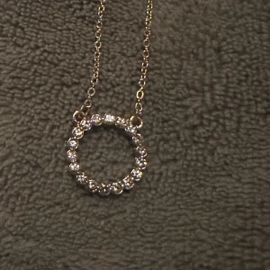 Glittrigt halsband och örhängen i cirkelform - Elegant set med ett halsband och matchande örhängen i cirkelform. Smyckena är dekorerade med glittrande stenar som ger en lyxig känsla. Perfekt för att lägga till lite extra glamour till din outfit.