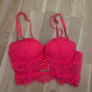 Rosa BH - strl 75A - Snygg spetsbh med justerbara axelband och snörning framtill. Denna kommer från New Yorker och är i storlek 75A. Nypris: ca 129kr. Säljer pga att den inte är i min storlek💕 Kontakta mig gärna för funderingar☺️