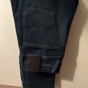 Mörkblå jeans från Replay - Säljer ett par snygga mörkblå jeans från Replay. Ambass storlek 31