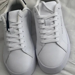 Tommy Hilfiger skor - Jag säljer dessa feta skor till ett bra och rimligt pris då dom aldrig är använda och passar bra till sommaren men kan även vara snyggt nu till vintern!! skicka dm vid funderingar och om priset vill diskuteras!