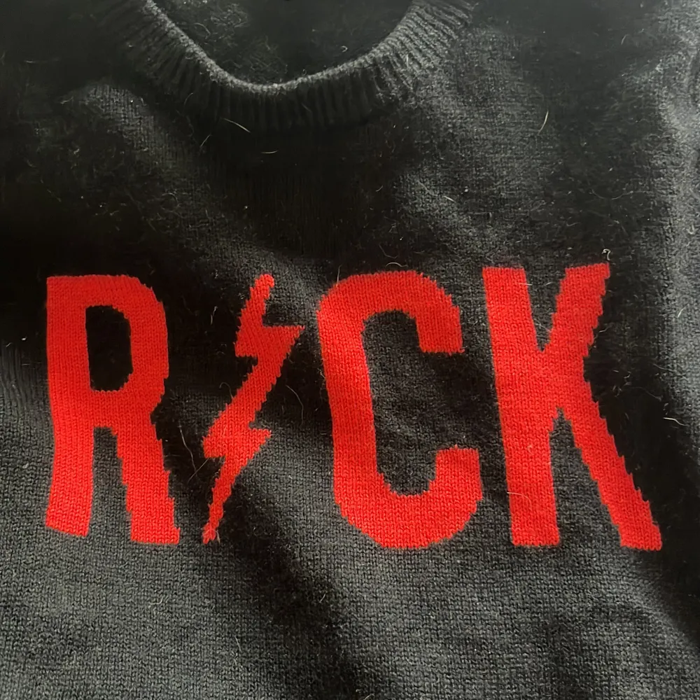 Säljer en cool svart tröja från Zadig & Voltaire med röd text 'ROCK' och en blixt på framsidan. Tröjan är i mycket bra skick och perfekt för höst och vinter. Den har långa ärmar och är supermjuk och bekväm. Perfekt för att ge din outfit en rockig touch! 🤘. Tröjor & Koftor.