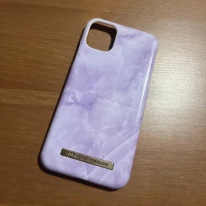Lila mobilskal från Ideal of Sweden - Säljer ett snyggt lila mobilskal från Ideal of Sweden. Skalet har en marmorerad design som ger en lyxig känsla. Det är i bra skick och passar perfekt för att skydda din telefon med stil. Perfekt för dig som vill ha något unikt och trendigt! 💜 30kr+frakt