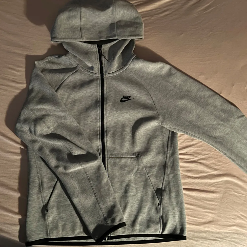 Säljer en Grå Nike Tech Fleece Set Perfekt för en avslappnad stil eller träning. Materialet är mjukt och skönt, idealiskt för både inomhus och utomhusaktiviteter. Tröjan är S och byxorna är M.. Sportswear.