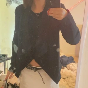 Svart kavaj - Säljer en stilren svart kavaj i bra skick. Perfekt för både vardag och fest. Den har en klassisk passform och långa ärmar. Passar utmärkt till både jeans och kjol. Hör av dig vid intresse!