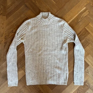 Cashmeretröja från Softgoat - Säljer en supermysig beige ribbad polotröja från Softgoat i 100% cashmere. Perfekt för höst och vinter med sin varma och sköna känsla. 
