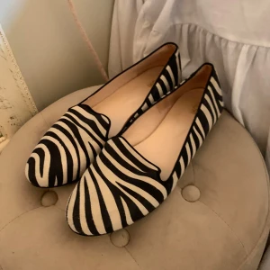 Zebramönstrade loafers - Snygga loafers med zebramönster i svart och vitt. Perfekta för att ge en cool touch till din outfit. Passar både till vardags och festliga tillfällen.