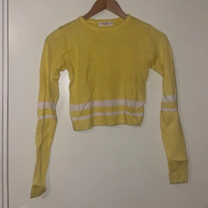 Gul croppad tröja med vita ränder - Säljer en superfin gul croppad tröja med vita ränder. Den är långärmad och perfekt för vinter och höst eftersom tyget är tjockt. Tröjan är i bra skick och passar perfekt till ett par jeans eller kjol. Perfekt för en casual look! 🌼