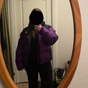 Lila pufferjacka från The North Face - Säljer en snygg lila pufferjacka från The North Face i storlek L. Jackan är perfekt för kalla dagar med sin tjocka vaddering och har en dragkedja framtill. Den har en cool svart detalj på axlarna och är superbekväm att ha på sig. Perfekt för vintern! ❄️ Ändvänd två vintrar, skriv privat om fler bilder eller om du har frågor💕 köpt för 4000 på Zalando🌸