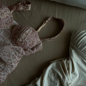 Klänningar från Oh Polly - Säljer två superfina klänningar med leopardmönster i ljusrosa och den andra i beige toner. Klänningen har vadderade kupor och en söt bandeau-stil med knytband. Perfekt för kväll, fest eller bara om du vill klä upp dig! 🐆