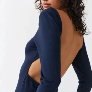 Mörkblå långklänning från Gina Tricot - Säljer en elegant mörkblå långklänning från Gina Tricot. Klänningen har en öppen rygg och långa ärmar, perfekt för en festlig kväll. Materialet är mjukt och följsamt, vilket ger en bekväm passform. Ett måste för garderoben! 💙