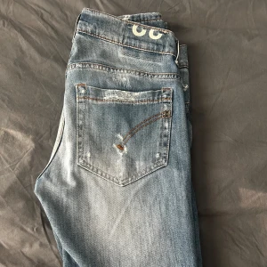 Dondup jeans med slitningar - Säljer ett par riktigt snygga dondup jeans i den populära modellen George. Storleken är 32 och passar mig som är ca 180cm perfekt. De är i väldigt bra skick. Hör av er vid frågor, köp eller funderingar.