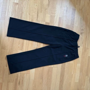 Svarta byxor från SNS - Svarta byxor från SNS med elastisk midja och avslappnad passform. Perfekta för en bekväm stil. Byxorna har en enkel design utan extra detaljer.