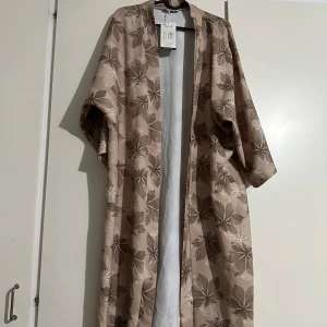 Beige kimono med blommönster - Snygg beige kimono  ny och oanvänd, oversize med ett band runt