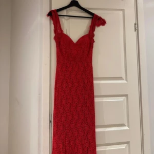 Röd spetsklänning - Snygg röd långklänning i spets med v-ringad design och öppen rygg. Perfekt för festliga tillfällen. Klänningen har en elegant passform och fina spetsdetaljer som ger en romantisk känsla. Själv hade jag den på min bal och var super nöjd💕
