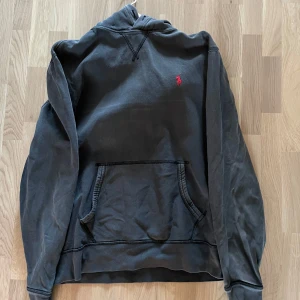 Ralph Lauren Hoodie M - Säljer min Hoodie från Ralph Lauren Denim&Supply i storlek M. Snygg svart blekt färg som passar till allt! Fint skick, finns inget att påpeka förutom att snörerna är ut dragna. Bara att höra av sig vid intresse! Mvh