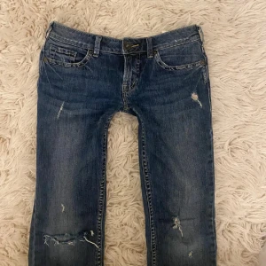 Lågmidjade blå bootcut jeans med slitningar - TRYCK GÄRNA PÅ KÖP NU!!!💞Säljer igen💞Så sjukt snygga och super lågmidjade bootcut jeans som tyvärr inte kommer till användning! Midjemått rakt över: ca 39 cm💞innerbenslängd: ca 81 cm💞Grenhöjd: Ca 19 cm💞 Skriv för bilder på hur jag tagit måtten ifall ni vill se💞 försöker att posta samma dag eller dagen efter💞Har en liten fläck men märks verkligen knappt! Får ej plats så skriv för bild på den💞💞 Köp helst med PostNord! 
