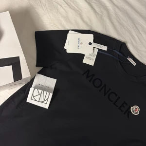 Moncler T-shirt - Svart Moncler T-Shirt köpt på Nk med kvitto och tags kvar. Väldigt stilren och aldrig använd men säljs ändå till ett bra pris. Storlek small och sitter korrekt till storleks anvisning. 