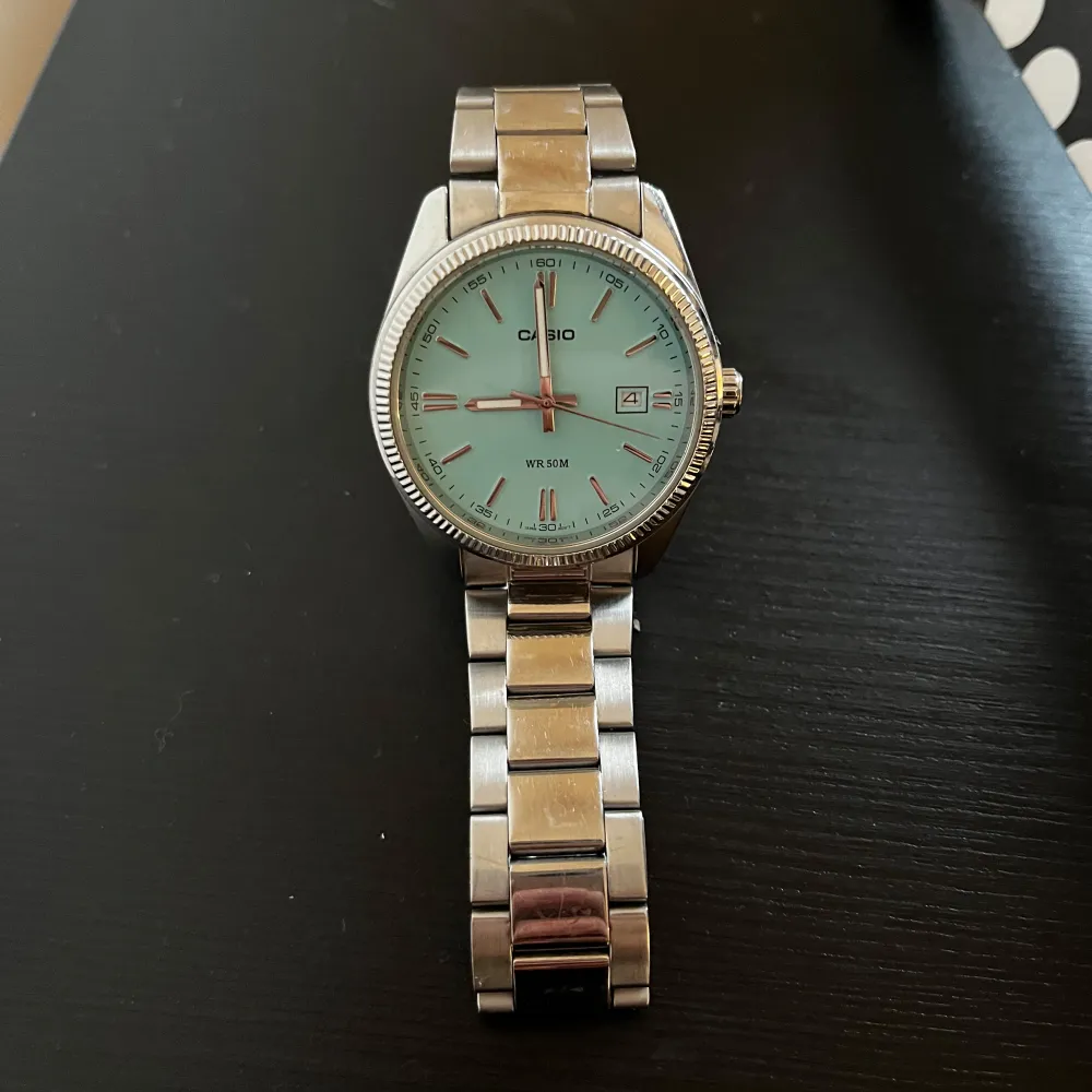 Snygg Casio-klocka med silverfärgad metallarmband och ljusblå urtavla. Klockan har datumvisning och är vattentät upp till 50 meter. Perfekt för dig som gillar en stilren och klassisk look. Pris kan discuteras. Asusteet.