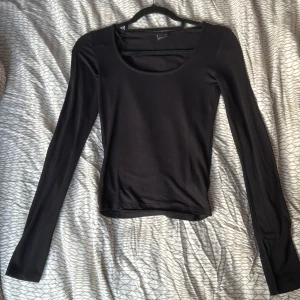 Svart långärmad topp från Gina Tricot - Säljer en stilren svart långärmad topp från Gina Tricot. Toppen har en rund halsringning och är perfekt för lager-på-lager eller att bära som den är. Passar till många olika outfits och tillfällen.