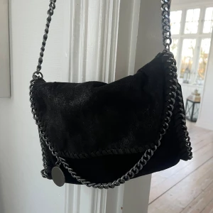 Svart axelväska med kedjedetaljer - Snygg svart axelväska med kedjedetaljer och leopardmönstrat foder. Väskan har en kedjerem och en magnetknapp för stängning!🙌🏻Gott skick! Pris kan diskuteras!