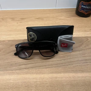 Svarta solglasögon från Ray-Ban - Tja, jag säljer ett par svarta raybans för dem som tycker att den vanliga storleken är lite stor. Den här modellen är 4mm kortare bredd än de andra vilken gör att det inte ser ut som att man bär simglasögon. Mått: 56-15mm. Fodral och putsduk ingår🙌