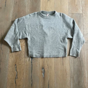 Grå stickad tröja - Säljer en grå stickad tröja från nelly med rund hals och ribbade kanter. Den är i strl. M!