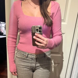Rosa ribbad topp - Säljer en snygg rosa ribbad topp från NA-KD x Amalie Star i storlek M. Toppen har en fyrkantig urringning och långa ärmar, perfekt för en stilren look. Passar bra till både jeans och kjol. 💖