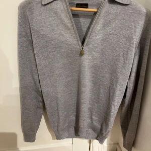 Grå merinoull half zip Stenströms - Säljer en stilren grå tröja från Stenströms i 100% merinoull. Tröjan har en dragkedja framtill och en klassisk krage. Perfekt för kyligare dagar med sin mjuka och varma känsla. Passar både till vardags och mer uppklädda tillfällen.