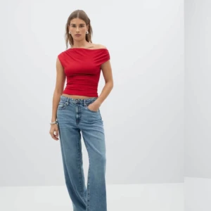 Röd offshoulder topp - Snygg röd offshoulder topp med tight passform. Perfekt för en kväll ute eller en speciell tillställning. Toppen har en elegant design som framhäver axlarna.