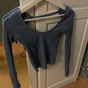 Blå öppen rygg  ribbad topp - Säljer en snygg blå ribbad topp med långa ärmar och en öppen rygg. Perfekt för en stilren look. Det är bara att fråga om du har några frågor!!!