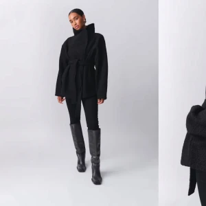 Svart kappa med knytband - Snygg svart kappa med knytband i midjan och bred krage. 