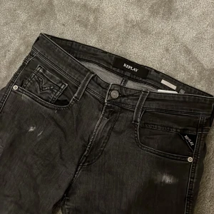 Svarta jeans från Replay - Asfeta svarta replay anbass jeans med slitningar från Replay i modellen Anbass. De är andvända 5-10 gånger och är 10/10 skick med inga defekter eller tecken på andvändning. Hör av dig om du undrar något! Nypris: 1600